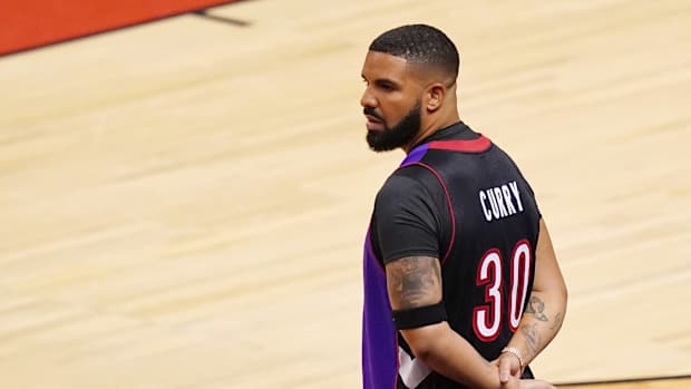 Drake standing courtside.